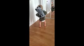 Cute toddler falls on his butt and starts laughing after walking into a mirror