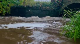 River Wharfe in West Yorkshire fast flowing with flooding on local roads.