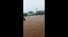 Locals wade through waist-deep floodwater in Indonesia