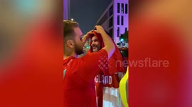 Locals help England fan with Qatari style red-and-white Arab headdress at World Cup