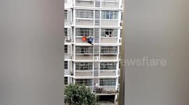 Neighbour climbs across building to rescue toddler dangling from 3rd-floor window