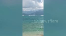 Waterspout forms along crystal blue waters near beach in the Philippines