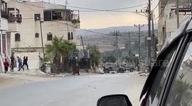 Palestinian protesters hurl stones towards Israeli forces during clashes in the town of Beit Ummar, in the West Bank city of Hebron