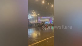 Street vendors hold onto clothes rack as freak winds blow stalls in Thailand