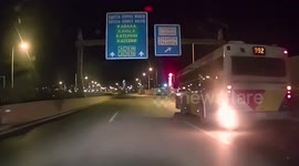 Bus drives along road in Greece despite flames emerging from engine