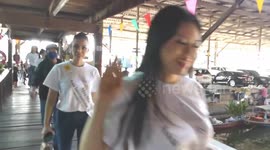 Beauty queen pageant hopefuls ride boat through floating market in Thailand