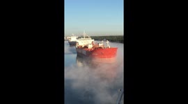 Mysterious fog settles on the water surrounding anchored vessels