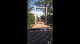 Motorist calmly drives over narrow, weak suspension bridge in Vietnam