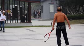 A Citizen Practices Playing Tennis Shirtless in Yichang, China