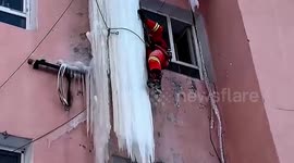 Firefighters remove giant ice column on building in China