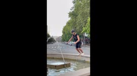 A man fails to jump in fountain and covers his fail with confident walk!
