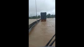 A truck driver moves through a flooded area on a highway in central Vietnam