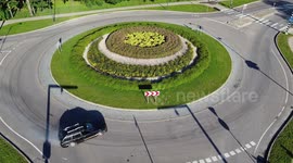 Areal shot: car driving in a roundabout and performing drifting on the street