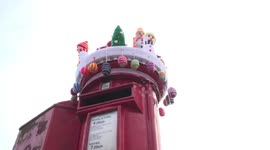 Mystery Knitter yarn bombs post box in the spirit of Christmas, Derbyshire, UK