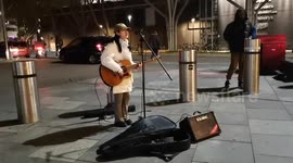 A young Chinese girl busking, singing Mandarin, London, UK
