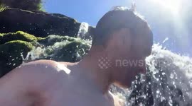 Having fun under a waterfall stream in the UK summer in the Brecon Beacons National park, enjoying the hot summer weather