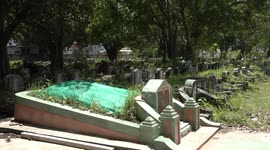 Cemetery lively with residents playing and having picnics around old tombs in Thailand