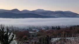 A time-lapse of a frozen fog flowing through The Glen of Aherlow with the Galty Mountains in the background in County Tipperary, Ireland