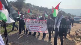 Israeli security forces take position as Palestinians wave national flags during a protest in Beit Dajan