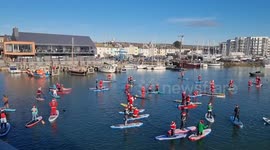 Dozens of Santas saunter down river Adur with paddle boards in West Sussex