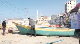 Palestinian maintain and repair the fishing boats using fiberglass material, at the Gaza seaport