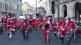 Dozens of Santas ride bicycles through Trafalgar Square in London