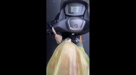 Cute dog enjoying the ride on a motorbike while inside a raincoat!