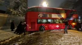 Londoners band together to move bus that got stuck across road during intense snowfall in the capital