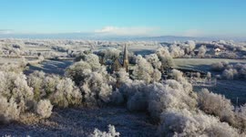 Drone shows frost-covered trees, church; scenic aftermath of Arctic Blast in UK