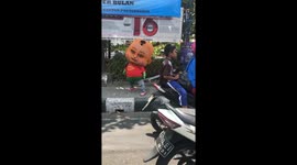 The creepy baby mascot was found dancing in the streets of Indonesia.