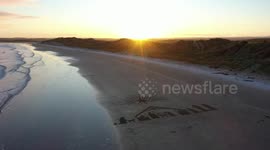 Drone footage captures giant beach nativity scene perfectly illuminated by stunning sunset