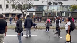 Protesters rip up bricks from the ground as they face riot police in Lima Peru