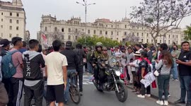 Riot police are jeered and whistled at by protesters in Lima as they drive through crowd