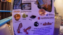 Watch this girl eat live squid squirting black ink at Thai market
