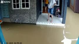 Dosey resident trips and falls into filthy floodwater outside home in Indonesia