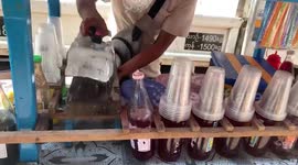 Old-fashioned Burmese street vendor prepares refreshing slushy at his stall