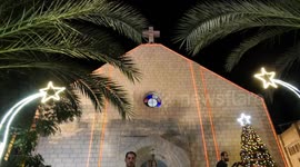 Palestinian christian Samer Tarzi attends the celebration lighting up the Christmas tree at the Holy Family Church