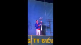 Circus act balances sword and glasses on his mouth whilst swinging