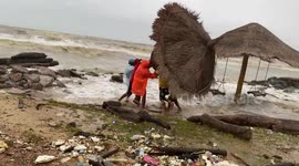 Strong waves batter beach parasols during storms in southern Thailand