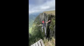 Venturesome man swings in the air like a pendulum following WILD canyon jump