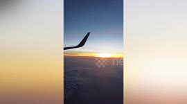 Plane passengers captivated by beautiful sunset seen from window