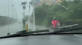 Flash flooding of the roads in Cartagena Colombia. Driving in one of the main roads in a taxi. Taxi driver drives on the pedestrian road to avoid flooding