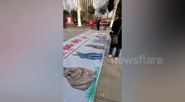 Deaf and non-verbal boy paints artwork on long paper scrolls in China