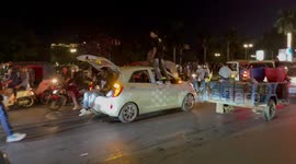 Men stand on cars celebrating New Year in Phnom Penh, Cambodia