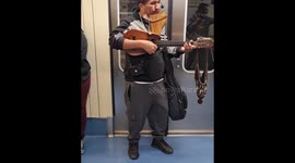 Bolivian musician playing pan futebol and charango as São Paulo's subways's
