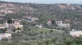 Smoke billows from a house as Israeli soldiers demolish the home of a Palestinian