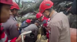 Indonesian police rescue trapped residents after trees fall on their house