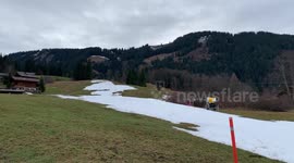 ADDITIONAL FOOTAGE - Skiers struggle to hit the slopes in the Alps after minimal snowfall renders the resorts barren