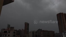 Multiple lightning bolts above tower blocks during a thunder storm in Spain. Slow motion.