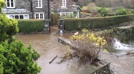 Flood water runs into the River Rothay after Storm Desmond